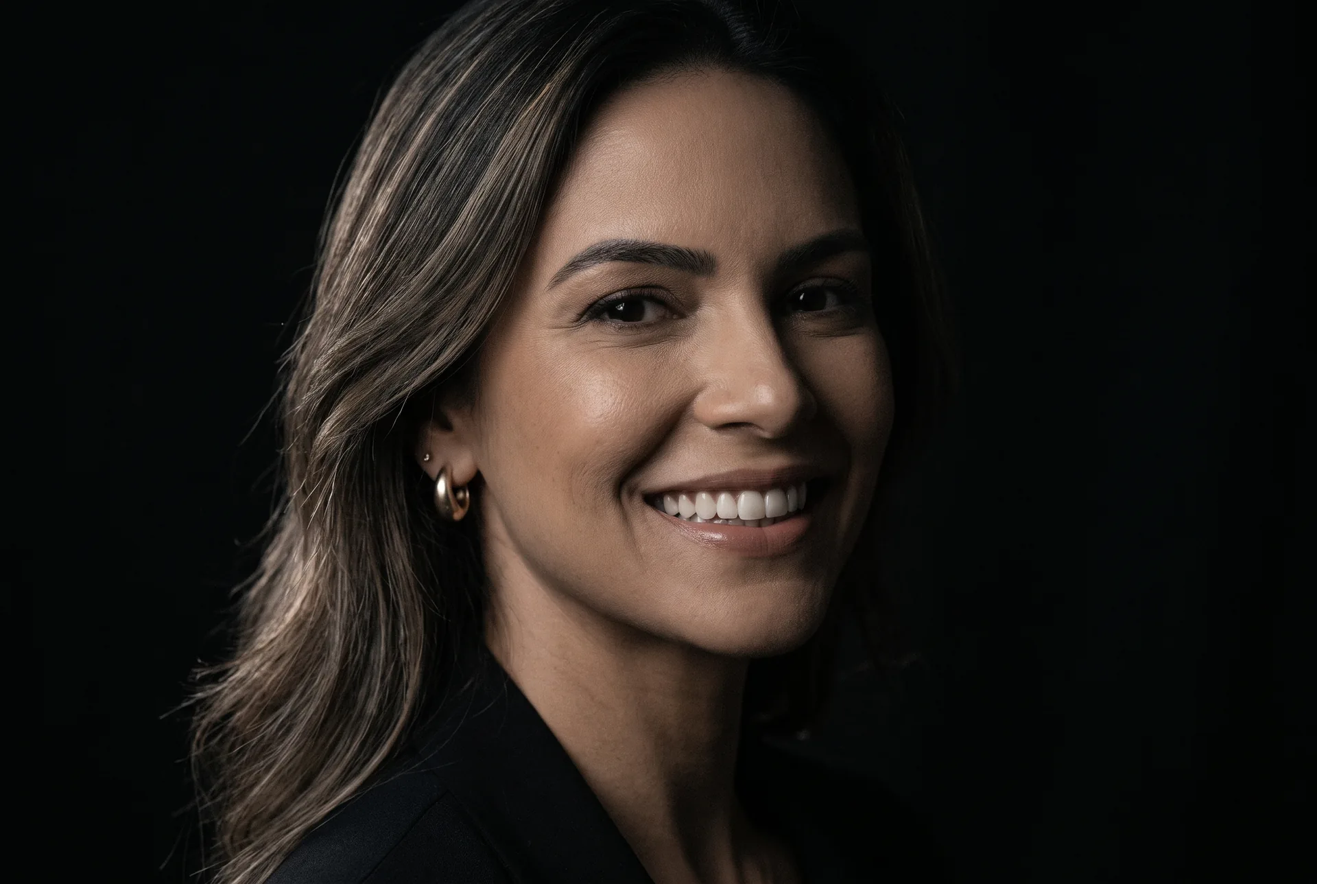 Retrato de mulher sorrindo sobre fundo escuro